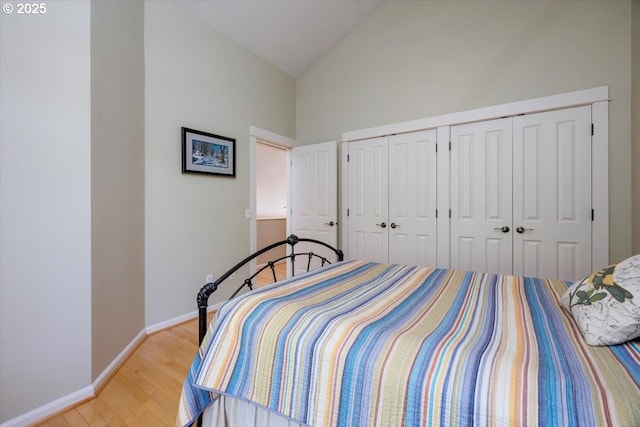 bedroom with baseboards, high vaulted ceiling, and light wood-style floors