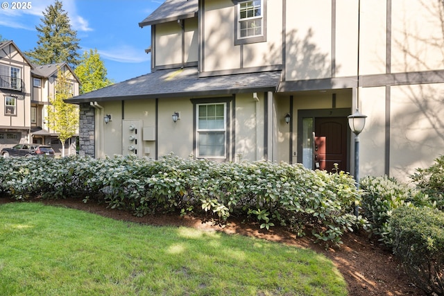3646 SW Baird St Unit 3, Portland, OR 97219 - view of front of property with stucco siding, a front yard, and roof with shingles