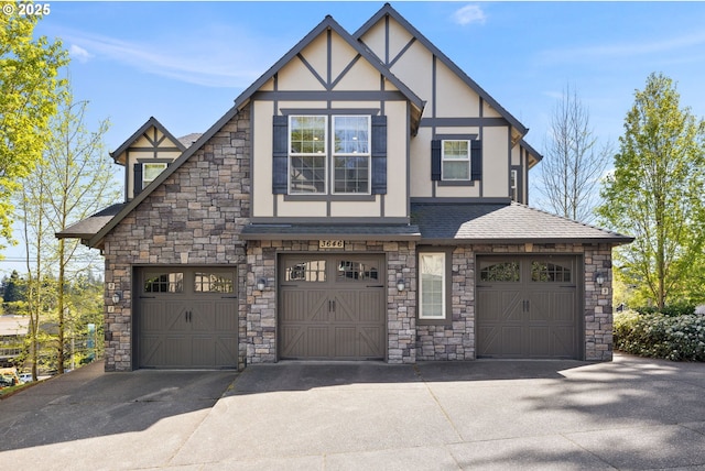 3646 SW Baird St Unit 3, Portland, OR 97219 - tudor house featuring stone siding, driveway, stucco siding, a garage, and roof with shingles
