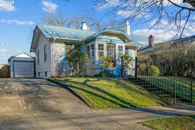 view of front of property featuring a garage, an outbuilding, and a front yard