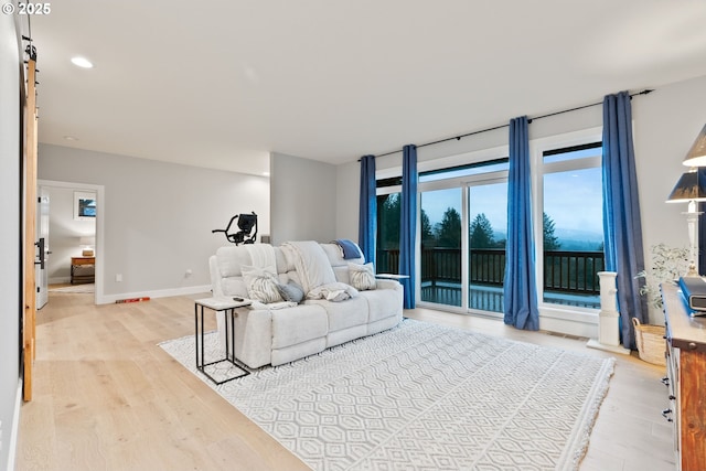 living room with recessed lighting, light wood-style floors, and baseboards
