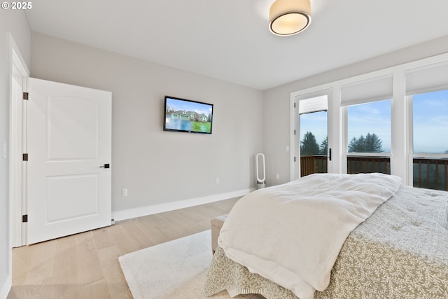 bedroom with baseboards, access to outside, and light wood finished floors