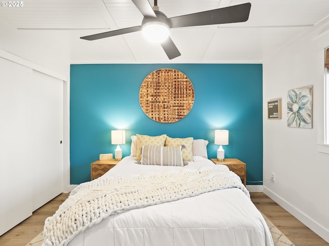 bedroom featuring hardwood / wood-style flooring, ceiling fan, and a closet