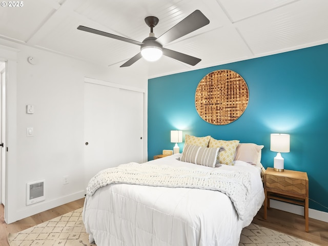 bedroom with ceiling fan, light hardwood / wood-style floors, and a closet