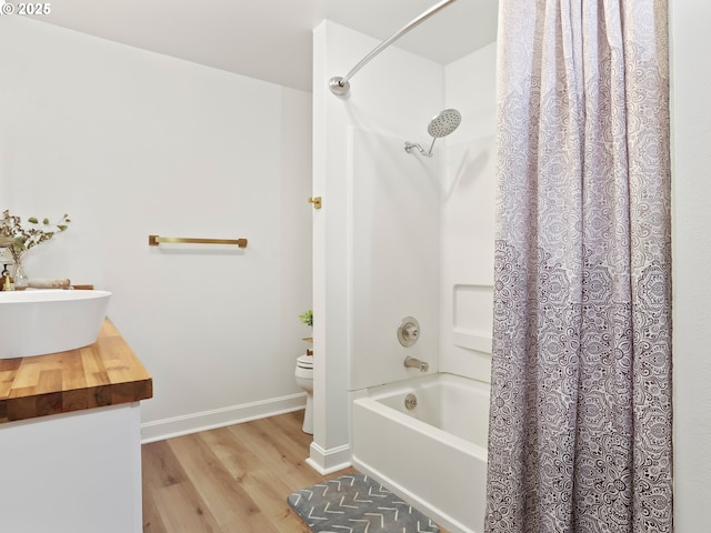 full bathroom with sink, hardwood / wood-style floors, shower / tub combo, and toilet