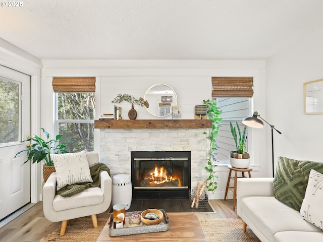 living area with hardwood / wood-style floors, a textured ceiling, and a fireplace