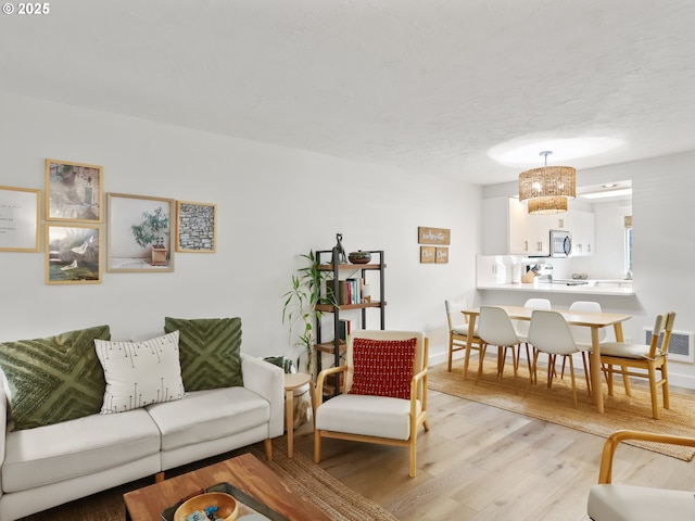 living room featuring light hardwood / wood-style flooring and a textured ceiling