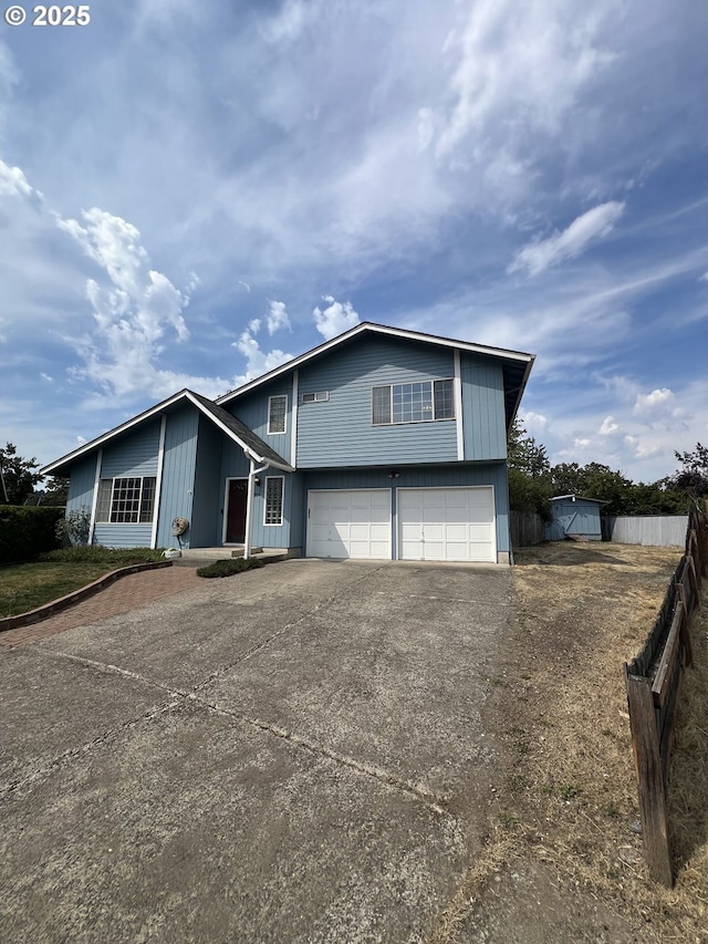 view of front of property featuring concrete driveway, fence, and a garage