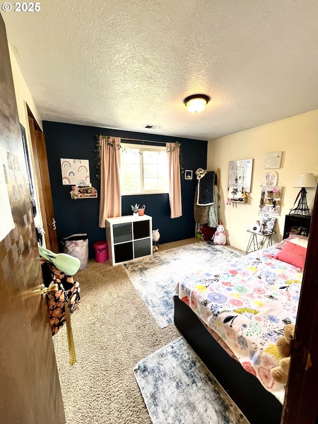 carpeted bedroom featuring visible vents and a textured ceiling