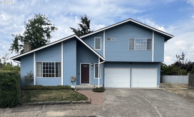 view of front of property with a chimney, an attached garage, concrete driveway, and fence