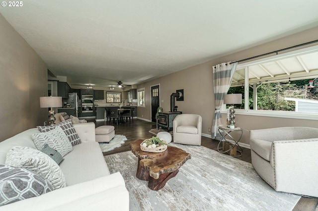 20256 S Swank Rd, Colton, OR 97017 - living area featuring a wood stove, baseboards, and dark wood-style floors