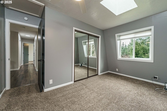 20256 S Swank Rd, Colton, OR 97017 - unfurnished bedroom with a ceiling fan, a closet, a skylight, carpet floors, and baseboards