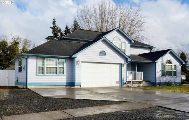 traditional-style house with driveway, a garage, and roof with shingles