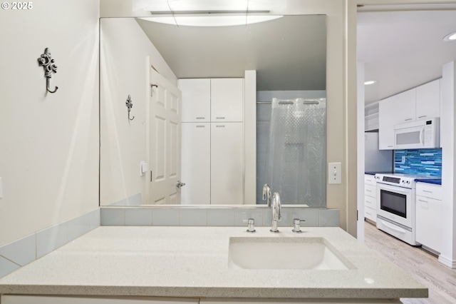 1132 SW 19th Ave Unit 512, Portland, OR 97205 - bathroom with vanity, a stall shower, decorative backsplash, wood finished floors, and recessed lighting