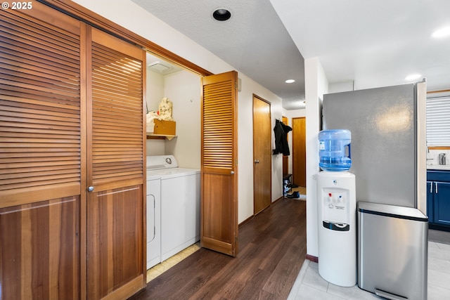 washroom with washing machine and dryer and hardwood / wood-style flooring