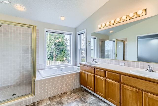 bathroom with vanity, plus walk in shower, vaulted ceiling, and a textured ceiling