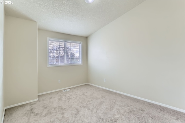 carpeted empty room with a textured ceiling