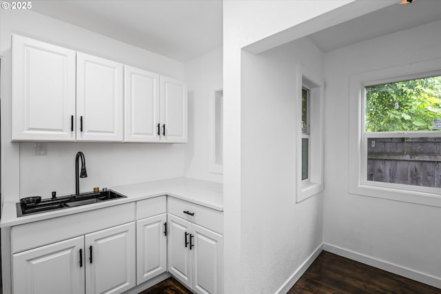 461 Blair Blvd, Eugene, OR 97402 - kitchen featuring a sink, white cabinets, dark wood-type flooring, light countertops, and baseboards