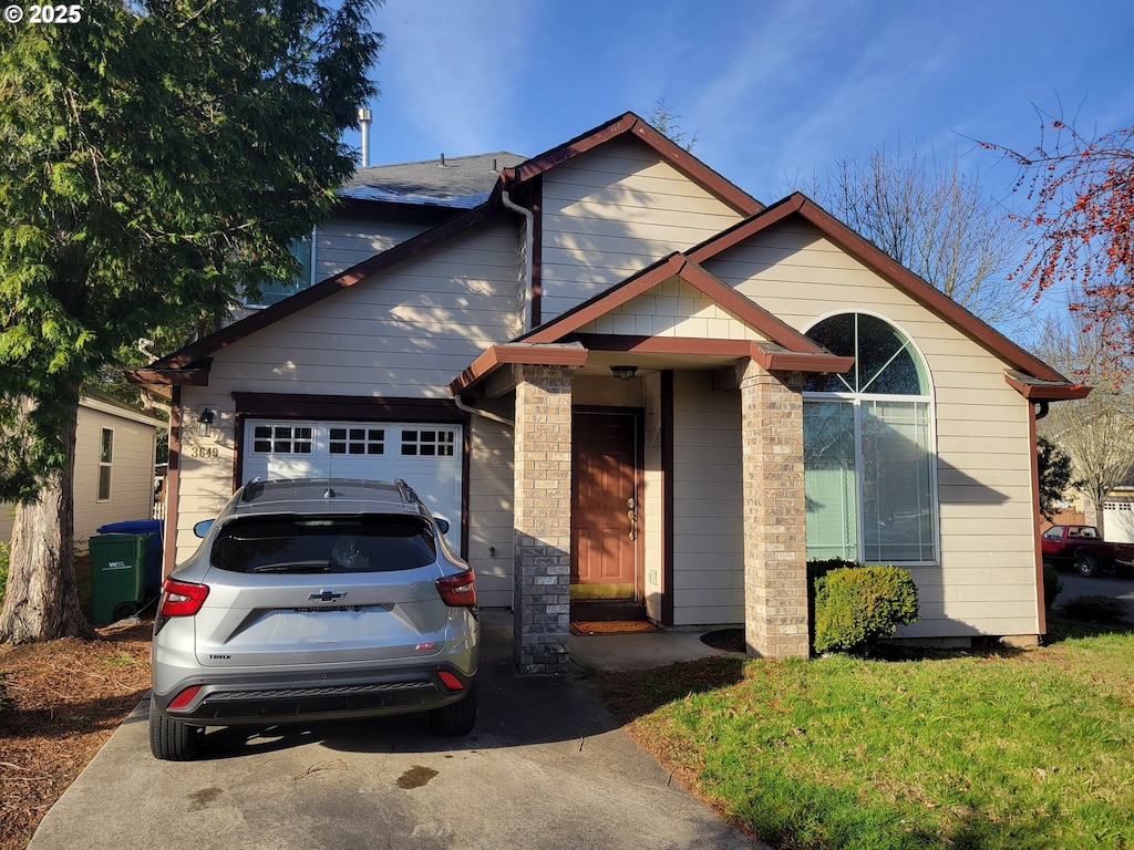 front of property with a garage and a front lawn