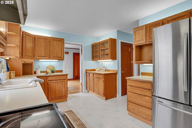 kitchen featuring freestanding refrigerator, open shelves, light floors, and light countertops