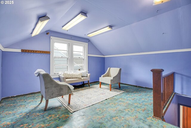 sitting room featuring vaulted ceiling and carpet flooring
