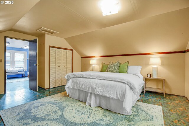 bedroom with attic access, lofted ceiling, and a closet