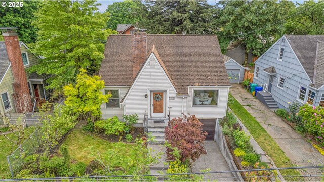 a-frame home with roof with shingles, driveway, a garage, and a chimney