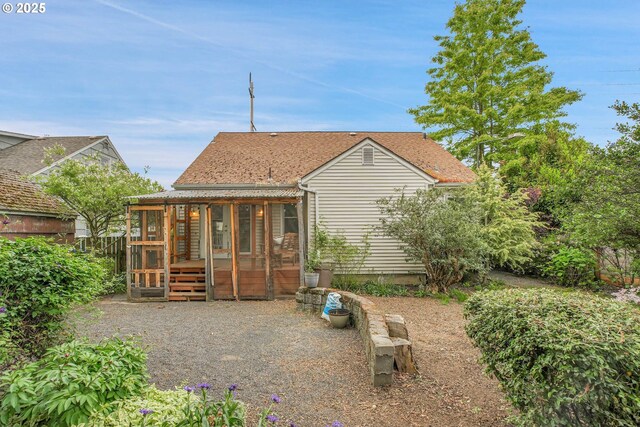 rear view of property featuring a sunroom