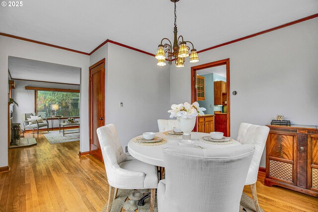 dining area featuring light wood-style flooring, a chandelier, ornamental molding, and baseboards