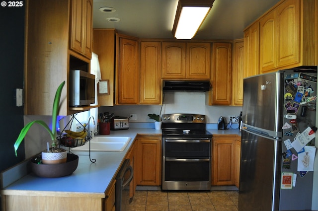 1529 Brentwood Ave, Eugene, OR 97404 - kitchen featuring appliances with stainless steel finishes, under cabinet range hood, light tile patterned floors, light countertops, and brown cabinets