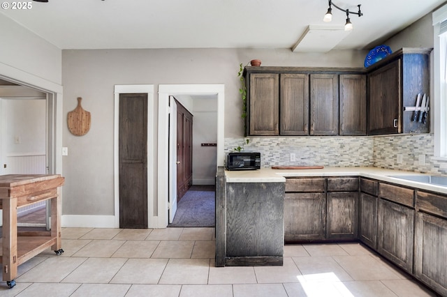 318 Koons St, Silverton, OR 97381 - kitchen featuring dark brown cabinets, light countertops, decorative backsplash, and light tile patterned floors