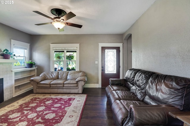 318 Koons St, Silverton, OR 97381 - living room with a ceiling fan, arched walkways, wood finished floors, a tiled fireplace, and baseboards