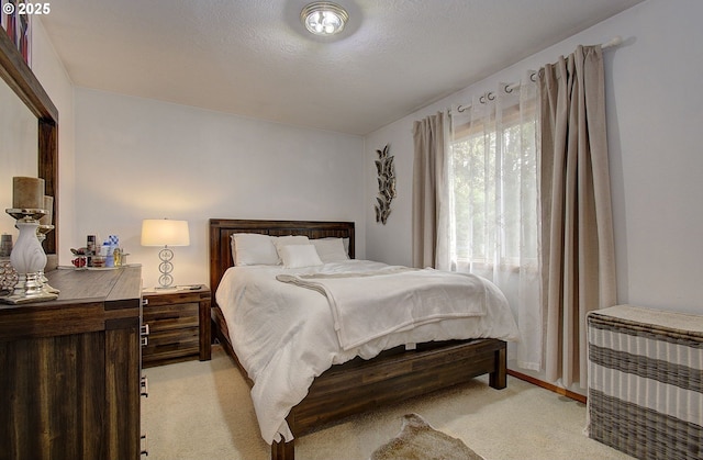 bedroom featuring light colored carpet and a textured ceiling