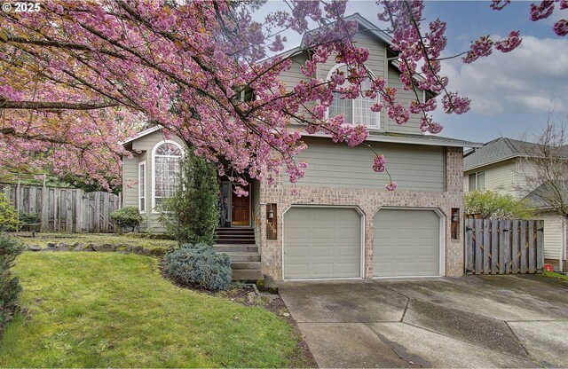 view of front facade featuring driveway, a front lawn, brick siding, a garage, and fence
