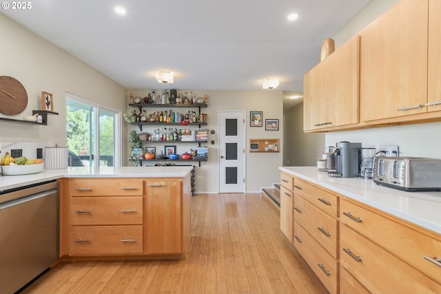 kitchen with stainless steel dishwasher, open shelves, light wood-style floors, and light countertops