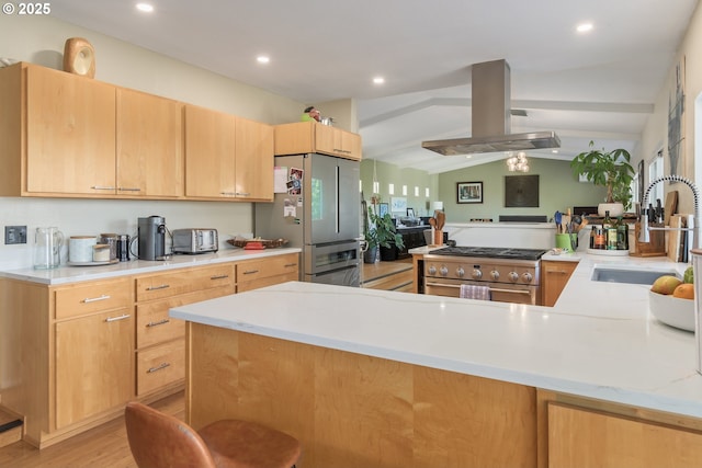 kitchen featuring a peninsula, lofted ceiling with beams, island range hood, a sink, and appliances with stainless steel finishes