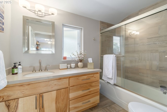 full bath featuring vanity, bath / shower combo with glass door, toilet, and lofted ceiling