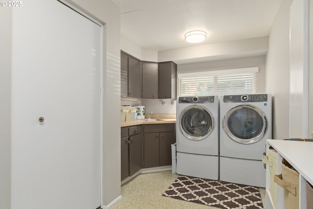 washroom with a sink, cabinet space, and washer and dryer
