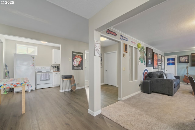 living area featuring baseboards, ornamental molding, and wood finished floors