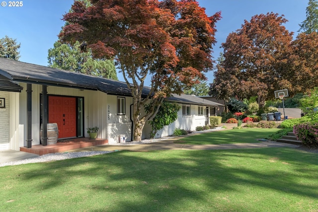 exterior space with board and batten siding and a front lawn