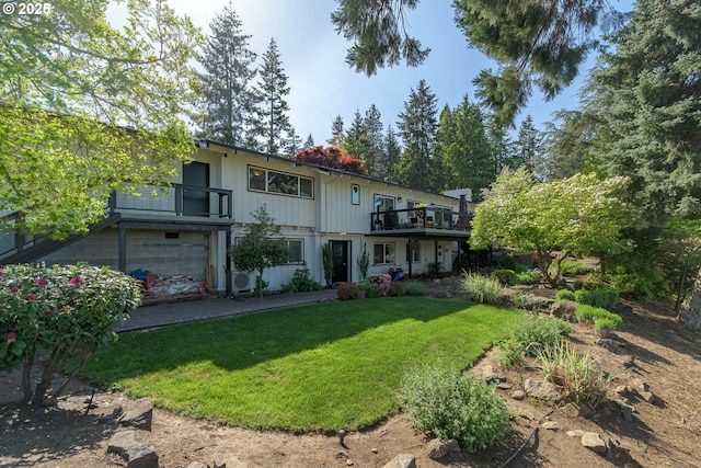 back of property with a lawn and a balcony