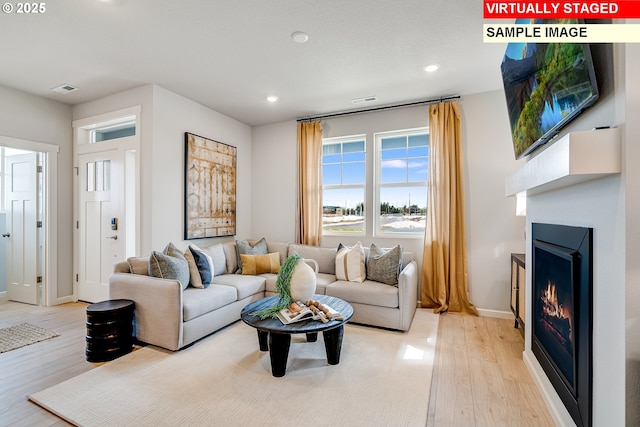 31697 NW Turel Dr, North Plains, OR 97133 - living room with a warm lit fireplace, light wood finished floors, recessed lighting, and baseboards