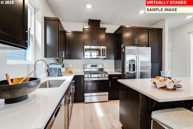 31697 NW Turel Dr, North Plains, OR 97133 - kitchen featuring appliances with stainless steel finishes, a sink, dark brown cabinets, recessed lighting, and light countertops