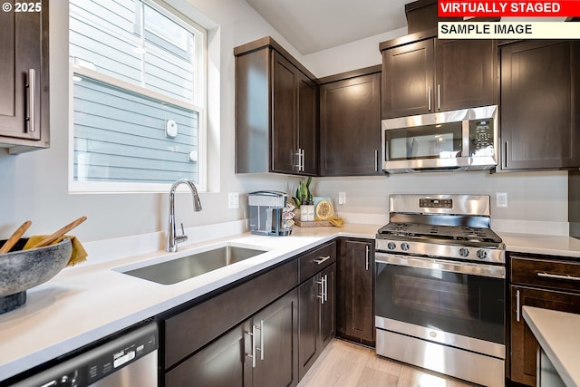 31697 NW Turel Dr, North Plains, OR 97133 - kitchen featuring appliances with stainless steel finishes, a sink, dark brown cabinetry, and light countertops