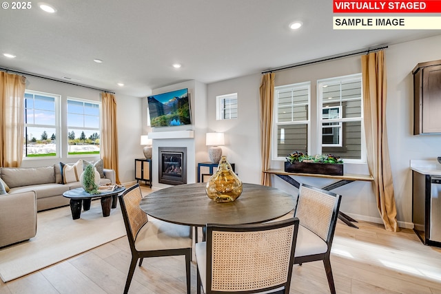 31697 NW Turel Dr, North Plains, OR 97133 - dining room with plenty of natural light, a glass covered fireplace, light wood-type flooring, recessed lighting, and baseboards