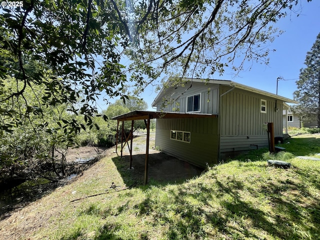 54824 Robinson Rd, Coquille, OR 97423 - view of side of home with board and batten siding, a yard, and an attached carport