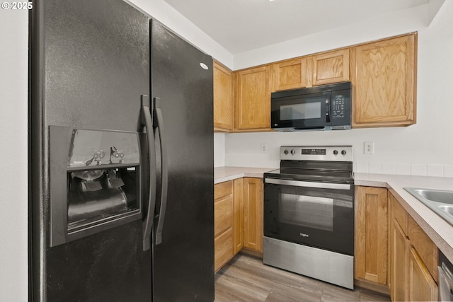 kitchen featuring black appliances and light hardwood / wood-style floors