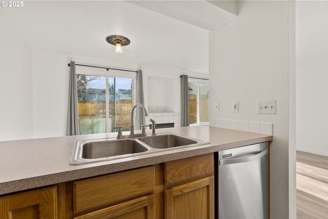 kitchen featuring sink, dishwasher, and light hardwood / wood-style floors