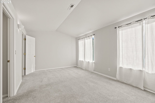 carpeted empty room with lofted ceiling