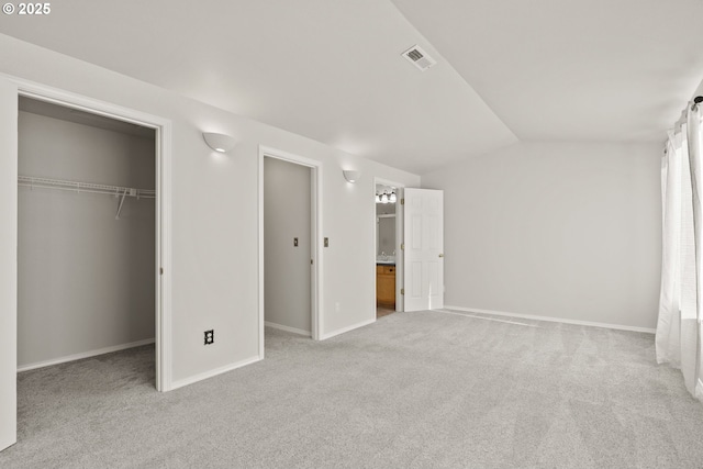 unfurnished bedroom with a closet, light colored carpet, and lofted ceiling